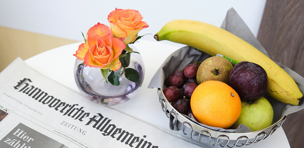 Obst und Blumen neben einer Zeitung